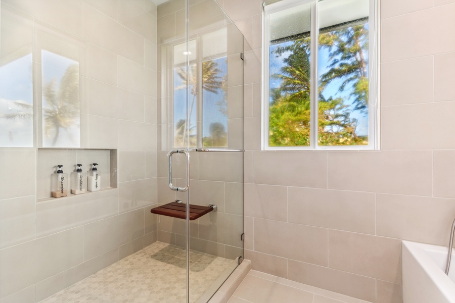 Walk-in shower with elegant tile work and built-in shelving for added convenience.