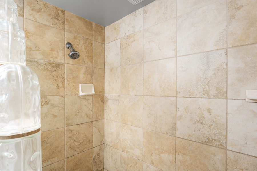 Stone-tiled walk-in shower with modern finishes for a spa-like experience.