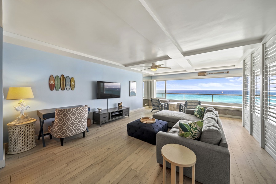 Sink into plush seating while ocean waves sparkle beyond your panoramic windows in this stylish beachfront retreat.