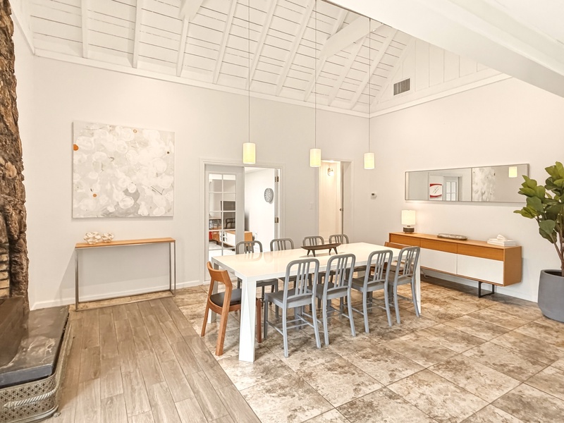 Gather around this stunning dining space where modern elegance meets rustic charm. The soaring vaulted ceiling creates an airy atmosphere for memorable meals.