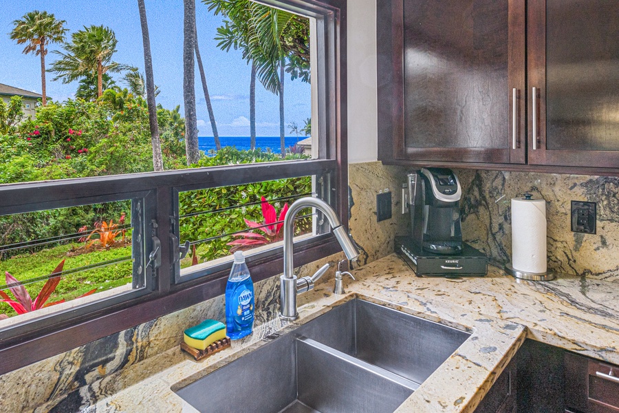 The kitchen sink features a window with stunning ocean views, adding a relaxing atmosphere while washing up.