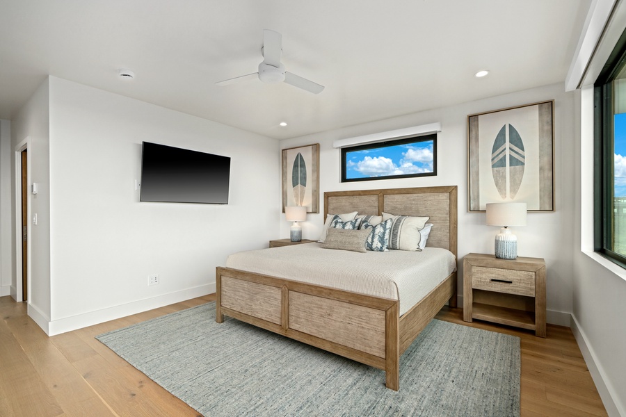 Drift off in your serene bedroom with coastal charm, featuring a plush king bed and wall-mounted TV for cozy evenings.