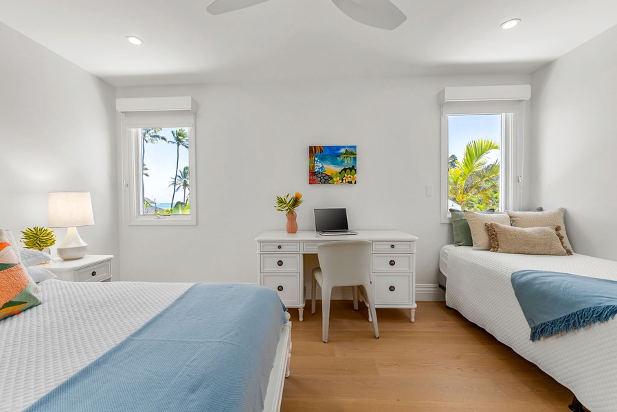 A writing desk, coastal artwork, and twin beds create a calm and flexible retreat for younger guests or extra visitors.