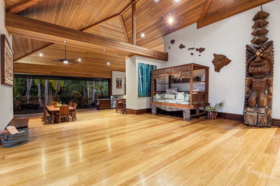 Step into this stunning open-concept living space where gleaming hardwood floors meet soaring wood-beamed ceilings, creating your perfect tropical retreat.