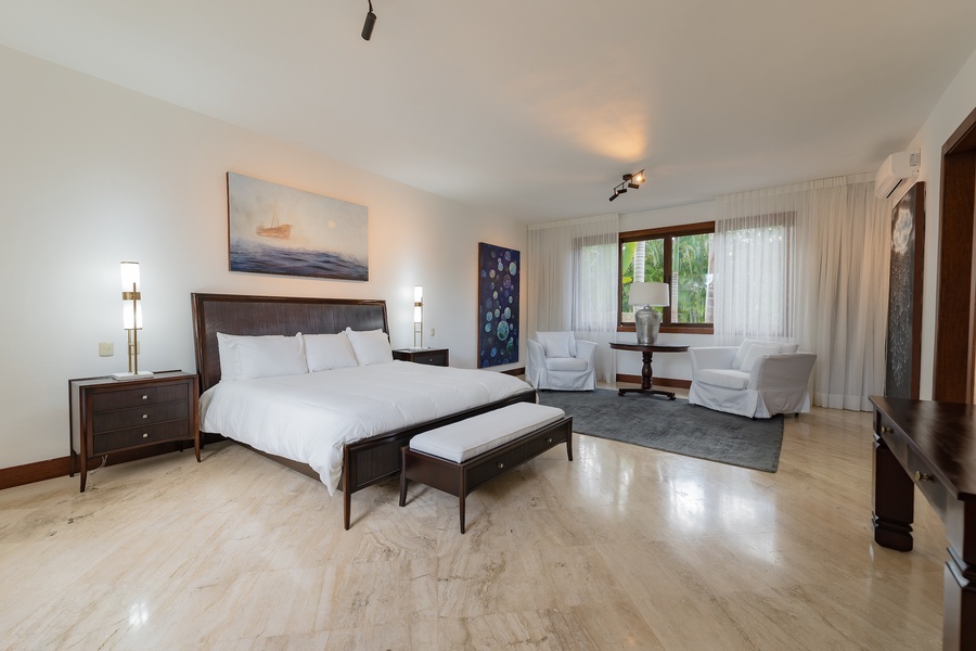 Bright and airy guest bedroom with modern furnishings and a relaxing seating area.