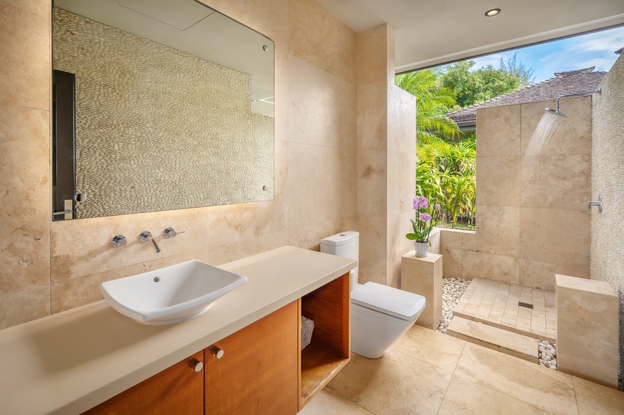 Refreshing garden shower with natural stone accents, bringing a tropical touch to your bathing experience.