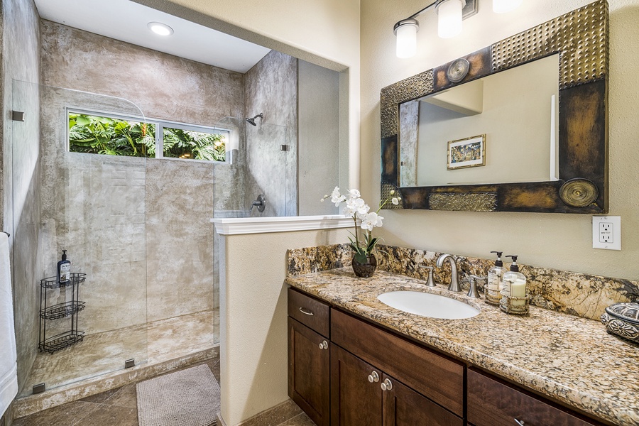 The guest bath includes a walk-in shower, granite vanity, and beautiful tilework for daily comfort.