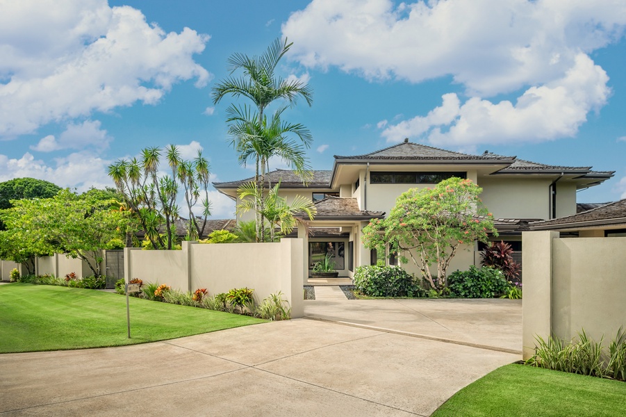 Spacious driveway leading to a welcoming entrance, surrounded by lush greenery.