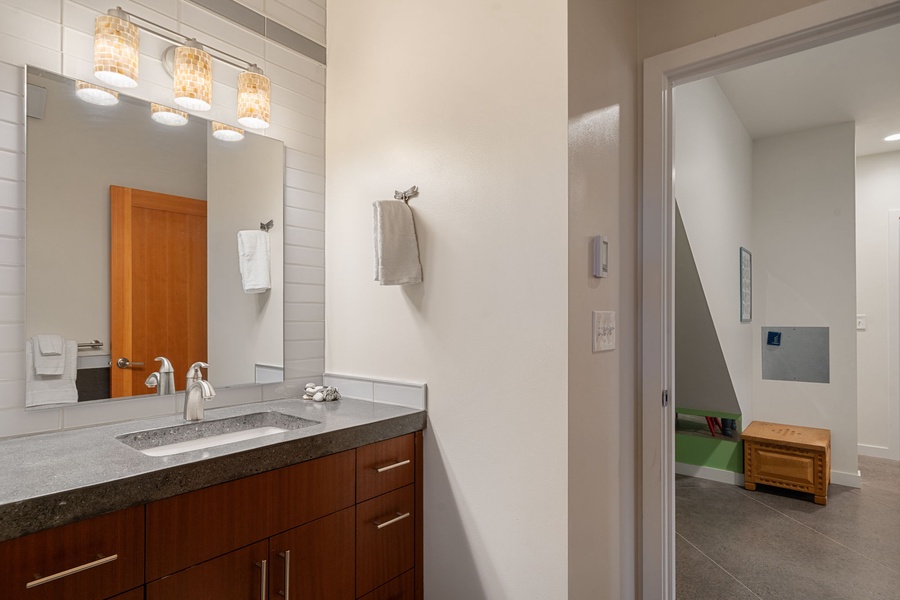 Freshen up in your stylish bathroom featuring modern fixtures, warm wood cabinetry, and thoughtful lighting.