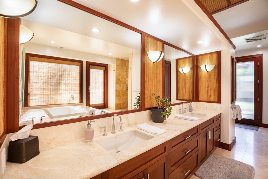 The primary bedroom's attached bathroom has a jetted soaking tub—ideal for unwinding after a long day—along with a spacious vanity and a separate walk-in shower.