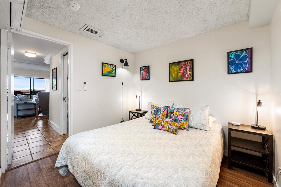 Sink into your cozy bed surrounded by vibrant tropical artwork and modern touches for the perfect restful retreat.