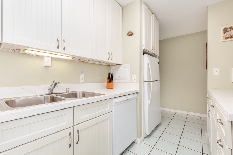 Ample appliances and tools with white cabinetry & counters.