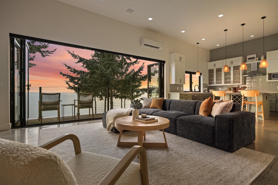 Indoor-outdoor flow designed for connection — doors open wide to frame peaceful twilight views of the shoreline.