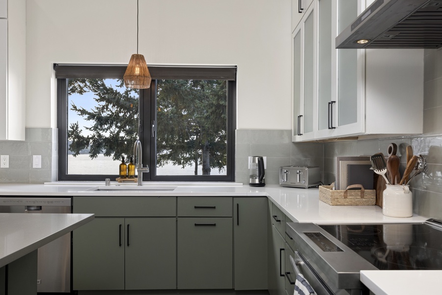 Bright kitchen corner with modern cabinetry and serene woodland views — a peaceful space to prep or pour coffee.
