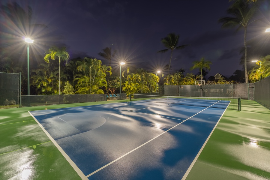 Tennis court under glowing lights provides the perfect space for an evening match.