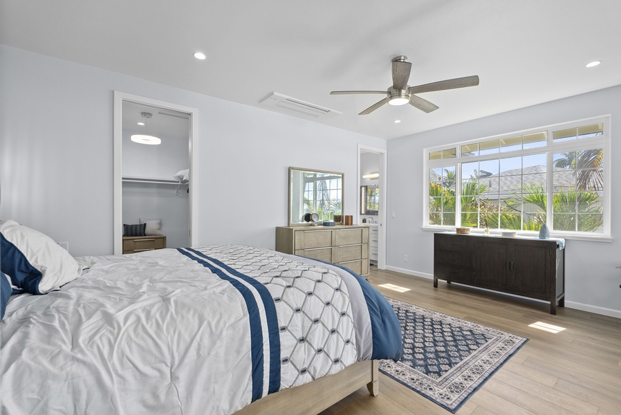 Spacious second-floor guest suite featuring large windows, crisp linens, and soothing coastal tones.