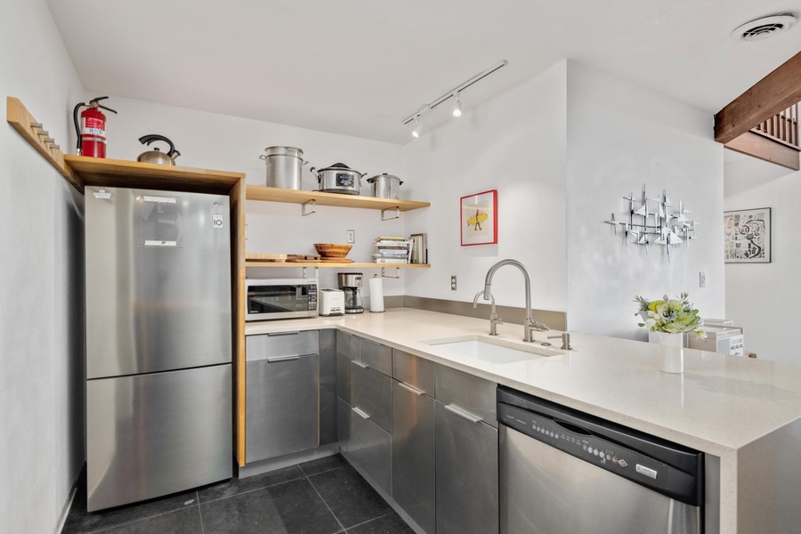 Fully-stocked kitchen with top-tiered appliances and wide counter space.