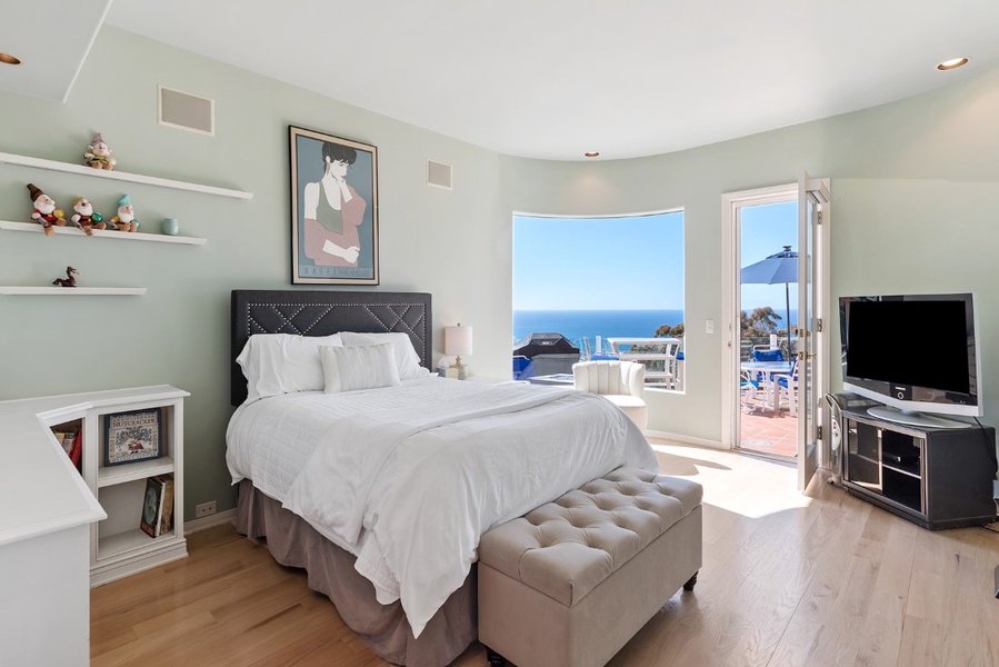 Bedroom #3 mid-level with Queen bed, television, closet, access to main patio, curved glass and beautiful views.  Privacy screens are used in lieu of window coverings