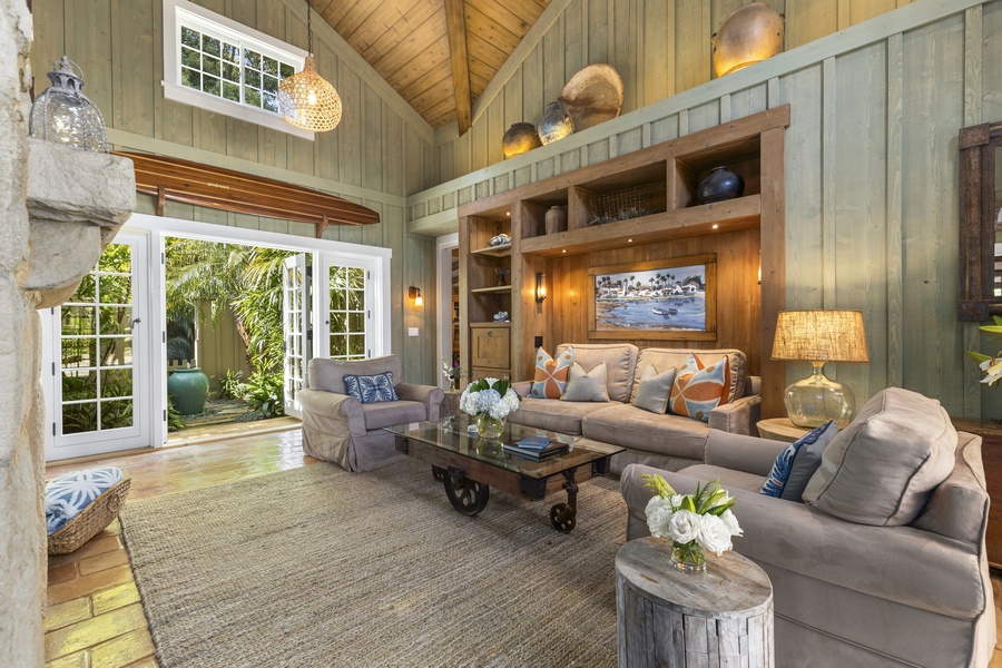 The main living area features vaulted high ceiling and sectional sofas.