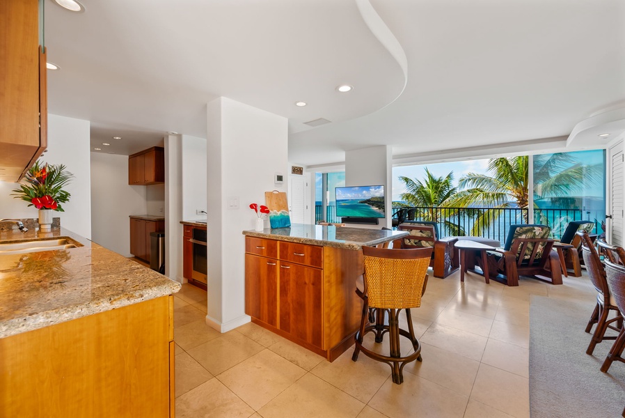 Charming breakfast bar with seating, leading to a cozy living area and balcony with stunning views of the sea.