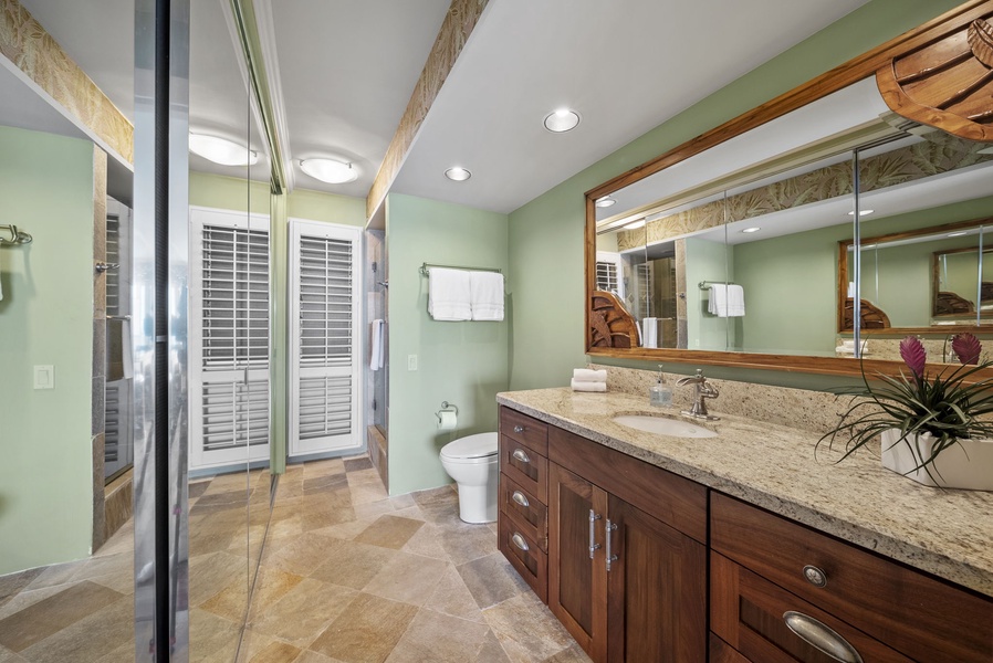 Elegant bathroom with granite counters, spacious vanity, and luxurious finishes—a perfect place to refresh after a day at the beach.