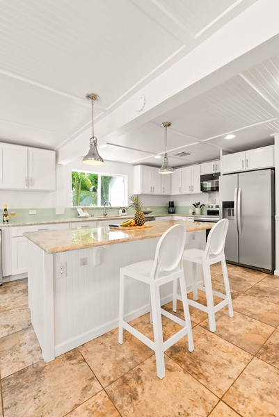 Gather around the spacious kitchen island with gleaming granite countertops, modern stainless appliances, and bright natural light streaming through the window. Your perfect spot for morning coffee and meal prep.