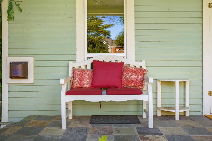 Step onto your private porch and sink into this charming bench with vibrant cushions, perfect for morning coffee or evening relaxation.