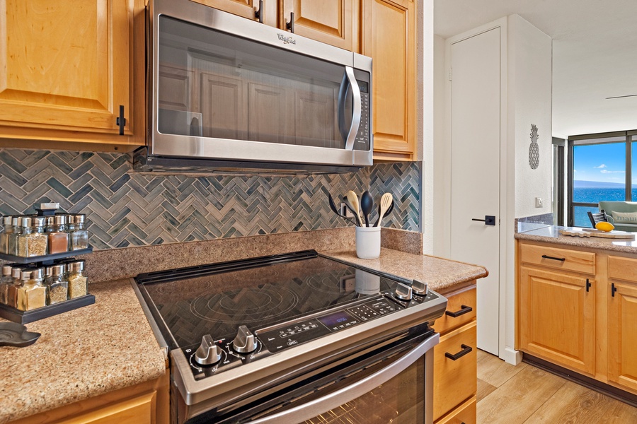 The modern kitchen is equipped with a sleek stove and microwave, complemented by a stylish herringbone tile backsplash.