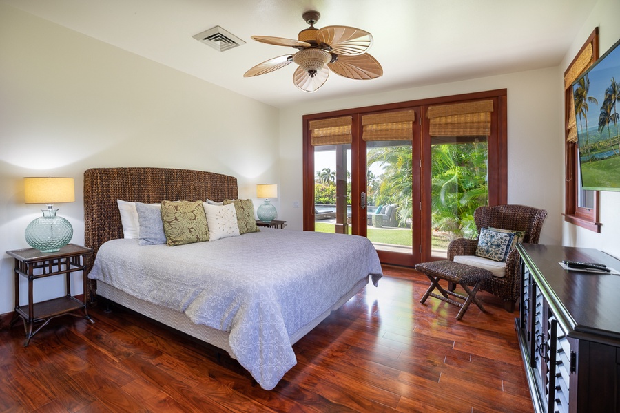 The second guest room in the main house has lanai access, a large bed, a ceiling fan, central air conditioning, and an en suite bathroom, in addition to featuring garden views.