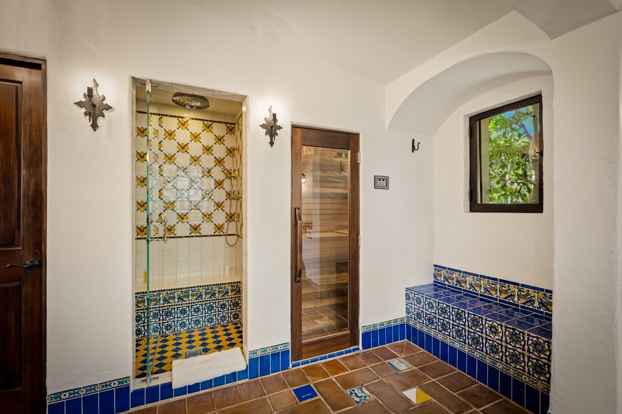 Step into your private spa sanctuary with stunning hand-painted tiles, steam shower, and sauna for ultimate relaxation.