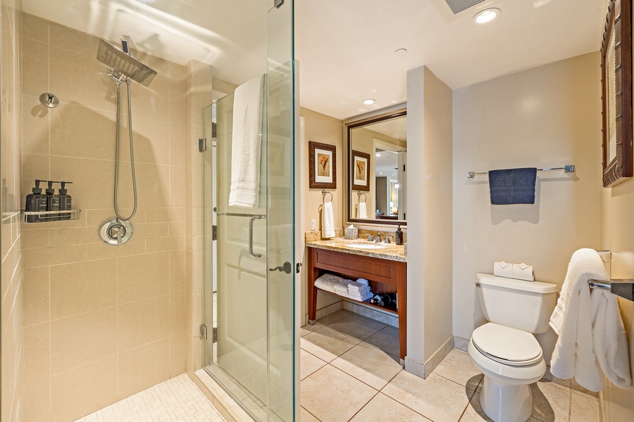 This contemporary bathroom is designed for comfort and style, featuring a separate glass shower and an appointed vanity area.