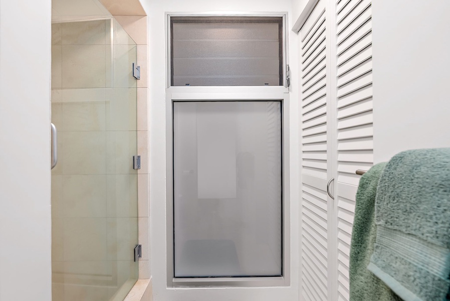 Glass-door walk-in shower with privacy window and fresh linens adds comfort to every day.