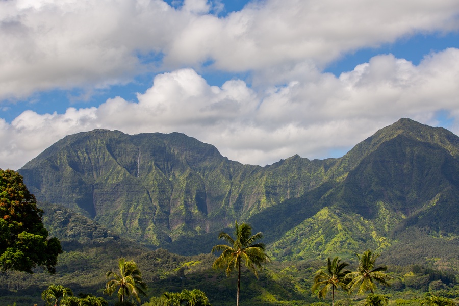 Mountain peaks rise through tropical vegetation, creating a stunning natural backdrop in this scenic island setting.