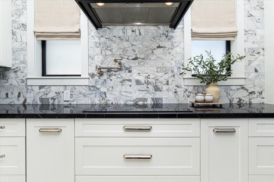 Detailed marble backsplash adds luxury and charm to the gourmet kitchen space.