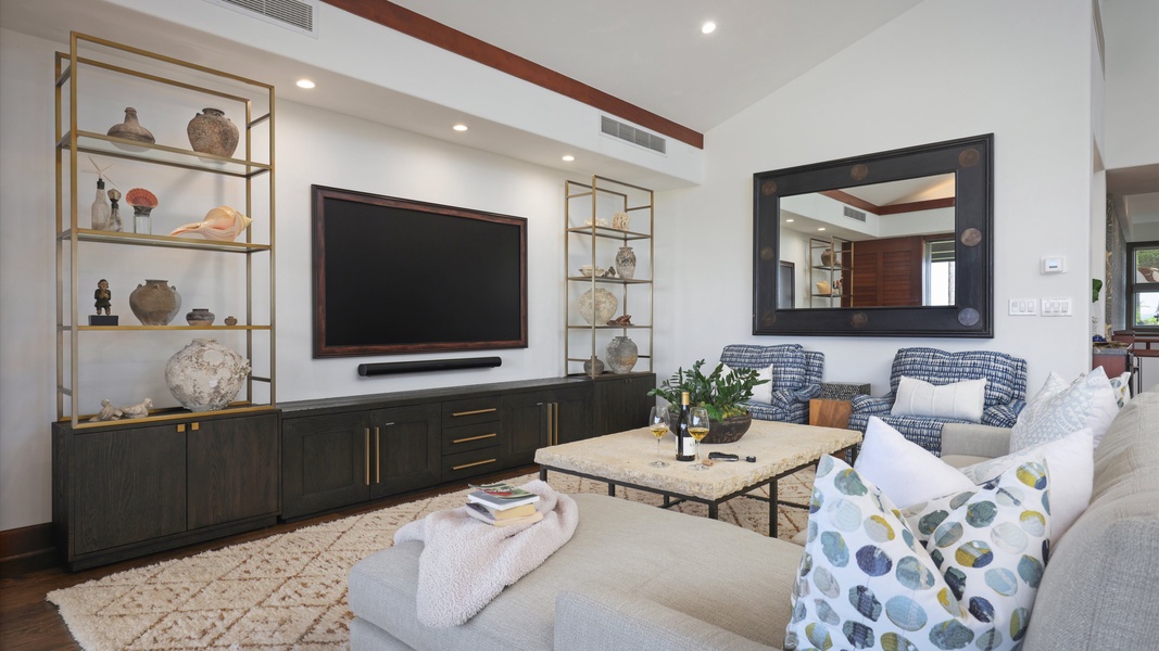 Cozy living space with plush seating, large TV, and modern island-inspired design.
