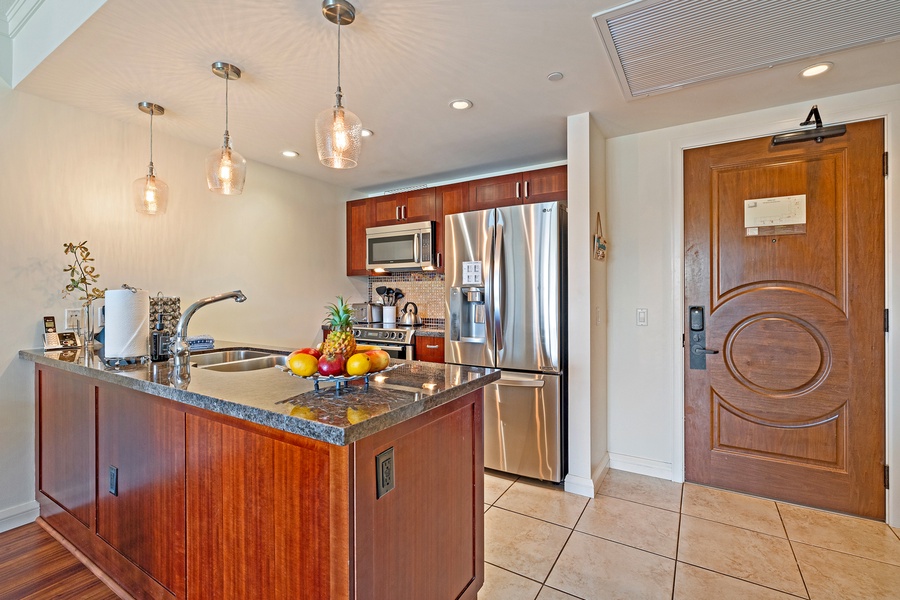 The kitchen island, with elegant pendant lighting and granite countertops, creates a warm and functional space for preparing meals