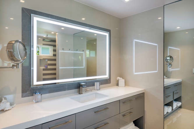 Guest ensuite with LED-lit mirror and sleek vanity—spa vibes for a luxury stay.