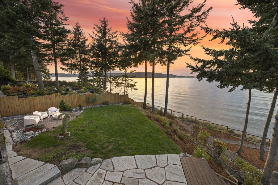 Expansive lawn and terraced landscaping lead gracefully down to the water’s edge.