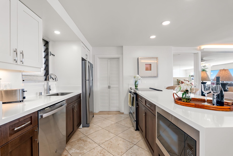 Thoughtfully designed galley kitchen with dual-tone cabinetry and full-size stainless appliances—ideal for prepping beach snacks or sunset dinners.
