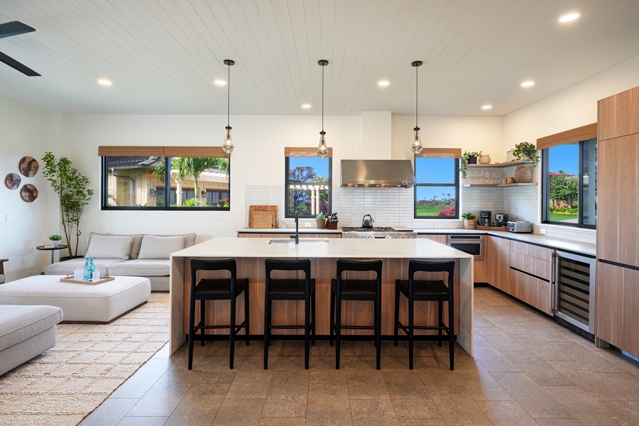 Chef's kitchen with sleek design and breakfast bar seating for four.
