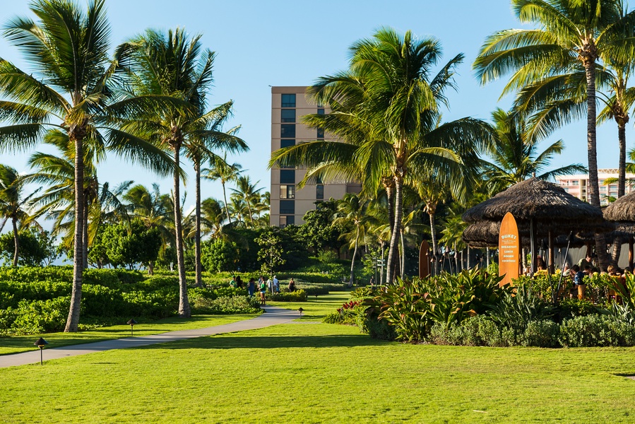 Lush lawns and shady palms surround Honua Kai Konea 230, offering a peaceful setting for your island retreat.