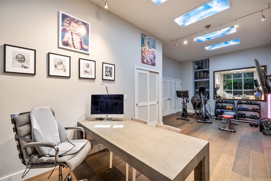 Versatile room with desk, workout gear, and lounge seating—stay productive or break a sweat.