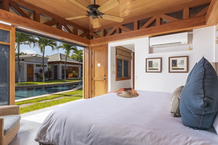 The third guest suite boasts serene views of the pool, with the primary bedroom situated across the water