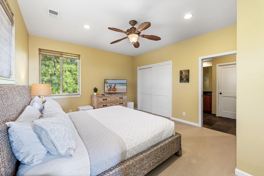 Spacious bedroom with a king-sized bed, cozy décor, and a peaceful garden view.