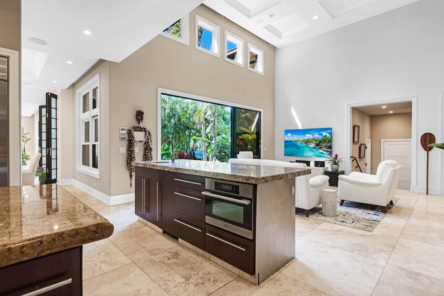 Gourmet kitchen with oversized island and garden views.