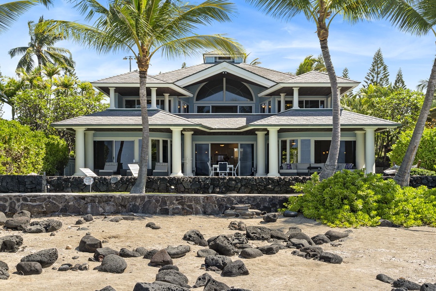 Sandy shoreline directly in front of the home completes the beachfront vibe.