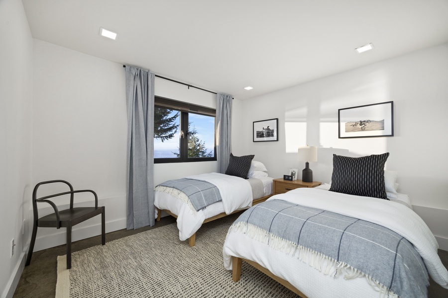 Bright twin bedroom with bay-view windows — ideal for kids, friends, or flexible sleeping arrangements.