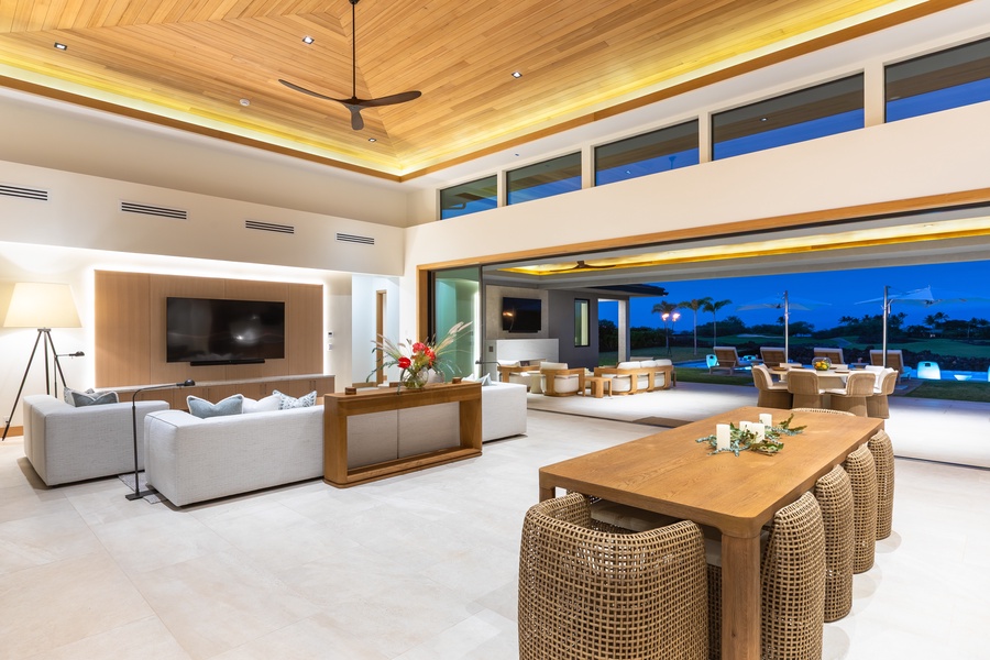 Unwind in this stunning open-plan living space where warm wood meets modern luxury, with soaring ceilings and seamless indoor-outdoor flow.