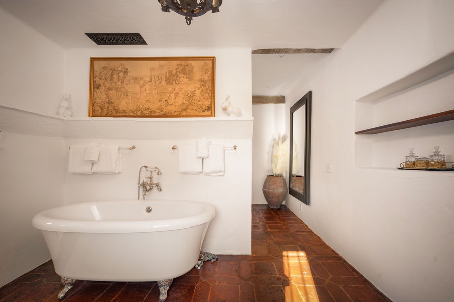 Soak in elegant luxury with your private clawfoot tub, surrounded by charming rustic details and artistic touches.