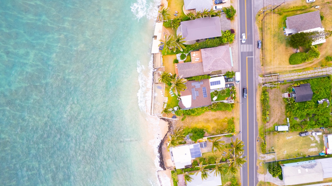 Aerial view of beachfront properties nestled along pristine turquoise waters and sandy coastline.